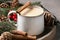 Tasty eggnog with cinnamon sticks on grey table