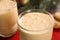 Tasty eggnog, cookies and fir branches on table, closeup