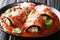 Tasty eggplant rolls stuffed with cheese and baked in tomato sauce close-up in a plate. horizontal