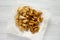 Tasty fastfood: fried potato wedges and chicken bites on a white wooden background, top view. Flat lay, overhead