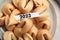 Tasty fortune cookies and paper with number 2023 on plate, top view