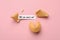 Tasty fortune cookies and paper with phrase Will you marry me? on pink background, above view