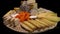 Tasty French cheeses on a plate on a black background