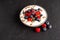 Tasty fresh blueberry raspberries  yoghurt shake dessert in ceramic bowl standing on black dark table background