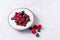 Tasty fresh blueberry raspberries yoghurt shake dessert in ceramic bowl standing on white table background