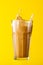 Tasty fresh iced creamy latte coffee splash straw in glass on ye