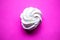 Tasty fresh meringue on bright pink background