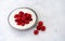 Tasty fresh raspberries yoghurt shake dessert in ceramic bowl standing on white table background