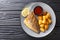 Tasty fried dorado fish fillet with potato garnish and sauces close-up on a plate. Horizontal top view