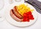 Tasty fried pork sausages with baked potatoes and pepper