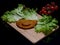 A tasty fried sofficino with a smile made with ketchup, salad leaves and cherry tomatoes on wooden cutting board