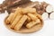 Tasty fried yucca sticks on white background