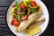 Tasty fried zander fillet with fresh vegetable salad close-up in a plate. Horizontal top view