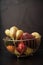 Tasty fruits in a metal basket. Wire basket with fruits on Black background. healthy eating concept