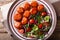 Tasty glazed meatballs with fresh vegetable salad close-up on a
