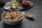 Tasty granola served with nuts and dry fruits on black table. Space for text
