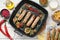 Tasty grilled sausages served on white wooden table, flat lay