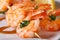 Tasty grilled shrimp on wooden skewers macro with sauce