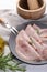 Tasty ham with rosemary and carving fork on white table