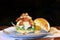 Tasty handmade hamburger sandwich with onion tomato lettuce and bread served on top of a stone on black background