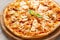 Tasty hawaiian pizza with chicken and pineapple on wooden cutting board