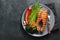 Tasty and healthy salmon steak with asparagus, broccoli and red pepper on a gray plate. Diet food on a dark background with copy