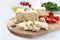 Tasty healthy sheep or goat feta cheese. Chunks of cheese on a wooden board on white background