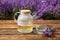 Tasty herbal tea and fresh lavender flowers on table in field