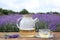 Tasty herbal tea and fresh lavender flowers on table in field