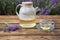 Tasty herbal tea and fresh lavender flowers on table in field