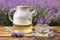 Tasty herbal tea and fresh lavender flowers on table in field