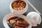 Tasty homemade asturian fabada; bowl with the beans and side dish with meat, jam, chorizo and blood sausages. Traditional