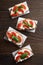 Tasty homemade brushetta with feta, tomatoes and basil on wooden table.