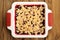 Tasty homemade cherry oat crumble in square white baking dish on