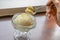 The tasty homemade cool vanilla ice cream scoop in glass cup on wood table.