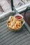 Tasty homemade crispy french fries potato tasty fast street food in wooden basket with ketchup.Unhealthy food,Poor street food, ob