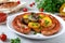 Tasty homemade grilled sausages with baked herb potatoes, mushrooms, cherry tomatoes and ketchup on a wooden background.