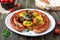 Tasty homemade grilled sausages with baked herb potatoes, mushrooms, cherry tomatoes and ketchup on a wooden background.