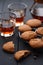 Tasty homemade oatmeal cookies with drip coffee in glasses on dark background