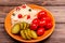 Tasty homemade pickled products on a plate sauerkraut, pickled tomatoes, pickle, swooden background