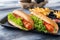 Tasty hot dogs with salad on wooden table