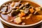 Tasty Hungarian Hot Goulash Soup Bograch or Gulas Lamb Meat Stew with Whole Grain Bread on Wooden Surface at Restaurant.