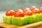 Tasty Japanese fantasy rolls with cherry tomatoes and green caviar served on bamboo plate
