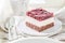 Tasty jelly cherry cake on white plate with cream