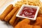 Tasty ketchup, fries, chicken nuggets and cheese sticks on plate, closeup