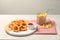 Tasty ketchup, fries and onion rings on light grey table, space for text