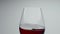 Tasty liquid waving inside glass closeup. Rose alcoholic drink shaking moving
