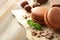 Tasty macarons, chocolate and hazelnuts on wooden background