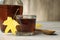 Tasty maple syrup, spoon and leaf on wooden table, closeup. Space for text