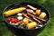 Tasty meat with vegetables and sausages being cooked on barbecue grill outdoors